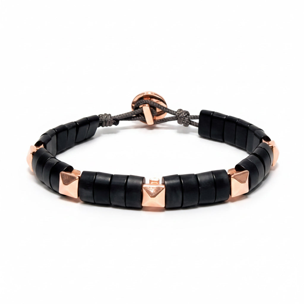 Black beaded horn bracelet with rose gold pyramids on a white background