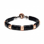 Black beaded horn bracelet with rose gold pyramids on a white background