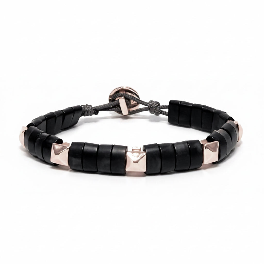 Black horn bracelet with white gold pyramid accents on a white background