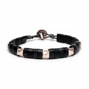 Black horn bracelet with white gold pyramid accents on a white background