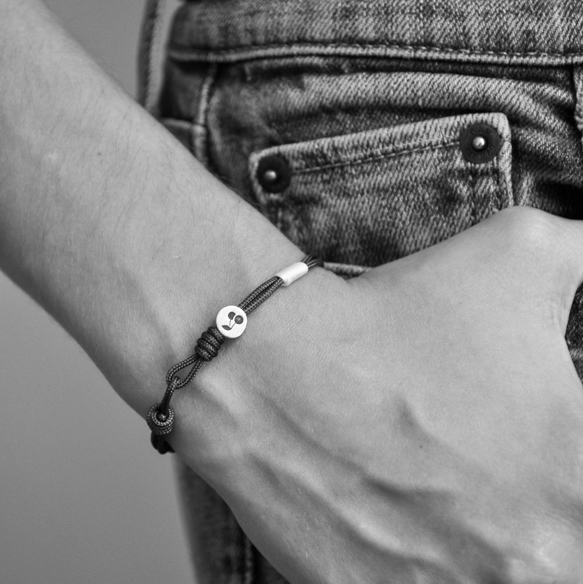 Cherry Bracelet: Brown Parachute Cord Bracelet with Red Details and Sterling Silver  Enhance your style with the Cherry bracelet, featuring a red parachute cord with brown details and a unique cherry design in sterling silver.&nbsp;