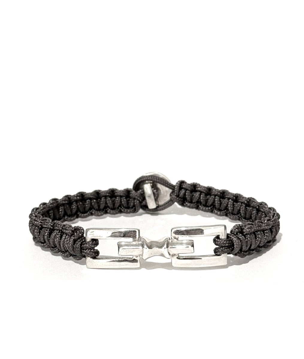 Grey hand braided bracelet with silver clasp on a white background