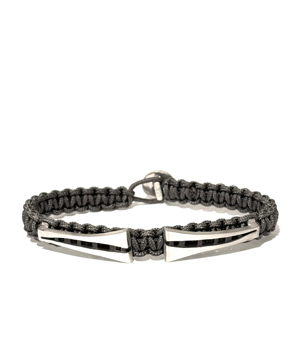 Grey braided bracelet with silver center pieces with a button clasp on a white background