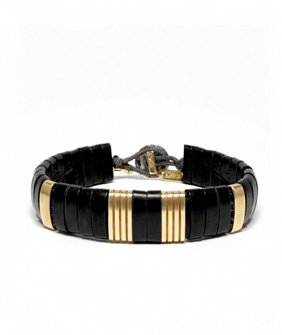 Handcrafted Parker bracelet featuring black water buffalo horn and ribbed 10K yellow gold links on a matte black parachute cord.