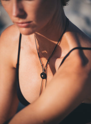 woman's neck wearing the Coco pendant in horn and gold