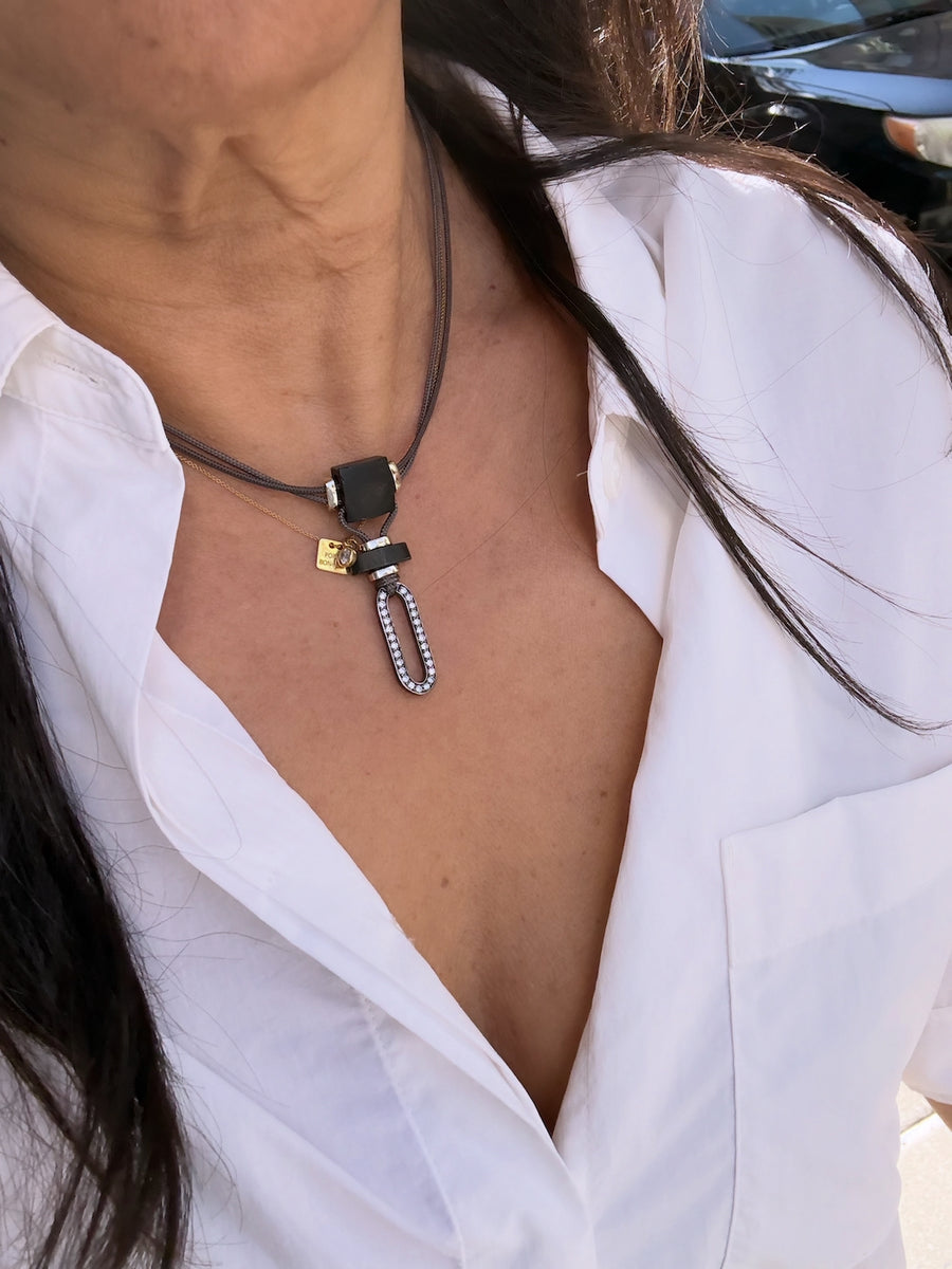Niru Horn necklace worn close to the neck over a white shirt — pavé diamond oblong pendant on grey parachute cord, ZADEH NY