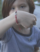Cherry Bracelet: Brown Parachute Cord Bracelet with Red Details and Sterling Silver  Enhance your style with the Cherry bracelet, featuring a red parachute cord with brown details and a unique cherry design in sterling silver.&nbsp;